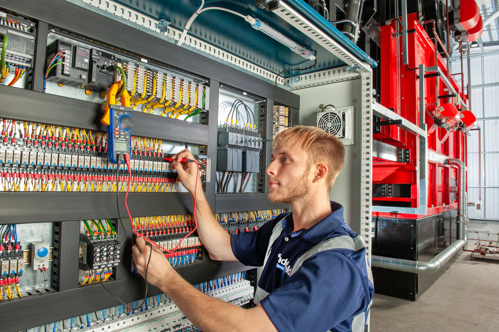 Addfield engineer operating a large industrial control panel during equipment setup